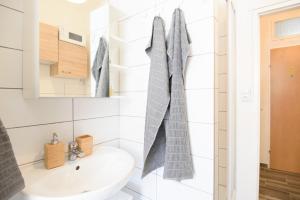 biała łazienka z umywalką i lustrem w obiekcie Vienna City Apartment Kempelengasse w Wiedniu