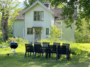 a grill and chairs in front of a house at Rosendala long stay by House Viola, 3 bedroom entire house in Bodafors, sleeps 7 in Bodafors
