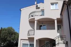a white building with balconies on it at Apartments Ivana in Jadrtovac