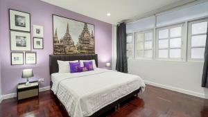 una camera da letto con un letto grande con pareti viola di BTS Asoke 6bedroom townhouse a Bang Kapi Altre 105 foto