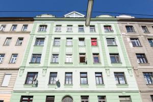 zielony i biały budynek z wieloma oknami w obiekcie Vienna City Apartment Kempelengasse w Wiedniu