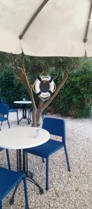 a soccer ball sitting on a table and chairs under an umbrella at Port Hotel, Tasucu in Silifke
