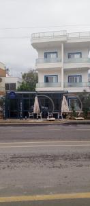 a building with tables and umbrellas in front of it at Port Hotel, Tasucu in Silifke