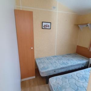 een kamer met 2 bedden en een deur bij Camping Baroudeurs in Lagraulière +12 foto's