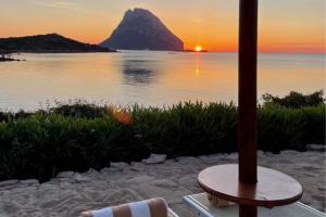a view of a sunset from a beach with an umbrella at Hotel Don Diego in Porto San Paolo