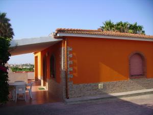 a side view of a orange house with a table at Finestra sul mare in Calabernardo