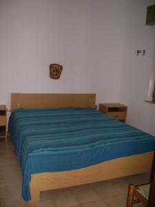 a bedroom with a bed with a blue blanket at Finestra sul mare in Calabernardo