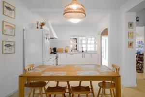 a kitchen with a wooden table and chairs at Vila Gorila - Coastal Home in Porto Formoso