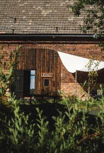 a brick building with a window and a sign on it at Wietorówka in Lubomierz