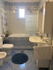 a bathroom with two sinks and a toilet and a tub at Green Oasis Villa in Gevgelija +23 photos