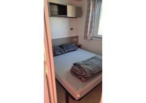 Un pat sau paturi într-o cameră la Mobil-home Clim, TV, LL Camping LA CARABASSE 4 étoiles - MH-A013