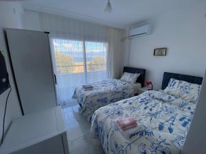 a bedroom with two beds and a window at Harmony Blue Pansiyon in Burhaniye