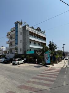 a hotel inn with cars parked in a parking lot at Ilio Boutique Hotel in Ksamil