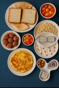 a table with plates of breakfast foods on it at Reef Home Hotel in Riyadh +10 photos