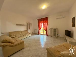 Una sala de estar con dos sofás y un televisor. en Villa Arya by Madreperla, en Taranto