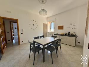 Un comedor con una mesa y sillas en una cocina. en Villa Arya by Madreperla, en Taranto