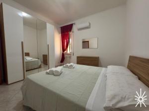 Un dormitorio con una cama grande con toallas. en Villa Arya by Madreperla, en Taranto