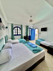 a large bedroom with three beds and a tv at Sea Horse Hotel Dahab in Dahab
