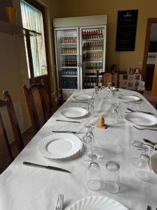 a long table with plates and wine glasses on it at Albergue de peregrino Cruz de Fierro in Foncebadón
