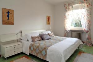 a bedroom with a bed and a dresser and a window at Villa Linda Bardolino in Bardolino
