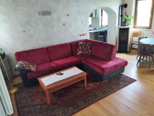 a living room with a red couch and a coffee table at Casa AgriBon in Sedico