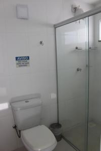 a bathroom with a toilet and a glass shower at Hotel Escarpas do Lago By San Diego in Capitólio
