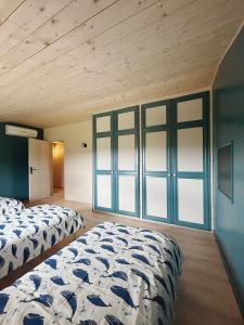 two beds in a room with blue walls and windows at La Casa d'Opale, maison de vacances 14 couchages in Montauban