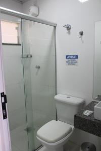 a bathroom with a toilet and a glass shower at Hotel Escarpas do Lago By San Diego in Capitólio