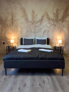 Un dormitorio con una cama grande con dos lámparas. en MorzePort Władysławowo, en Władysławowo