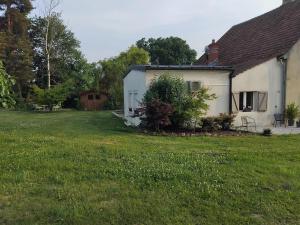 una casa bianca con un cortile accanto a una casa di Maison pétanque piscine 2 à 6 personnes a Chevigny-en-Valière