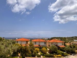 a group of houses with orange roofs on a hill at The Big Olive Tree in Hanioti