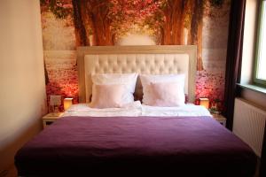 リューネブルクにあるUma Rosaのベッドルーム1室(紫色のシーツと枕が備わる大型ベッド1台付)