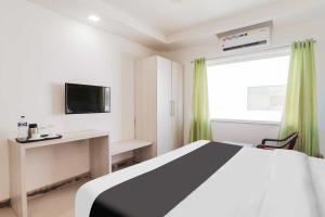 a bedroom with a bed and a desk and a television at Hotel O Civil Lines Near Old Bus Stand in Bareilly