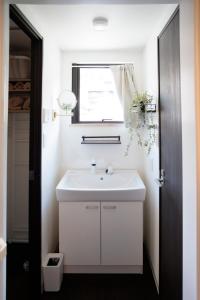 a bathroom with a white sink and a window at ハーモニーヒルズVilla箱根強羅 in Hakone +64 photos