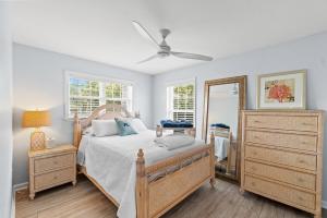 ポート・セント・ジョーにあるPrivate Pool, Beach Access, Luxe Kitchen, Fire Pit & Outdoor Entertaining Spaceのベッドとドレッサーと鏡のある寝室 +26枚の写真