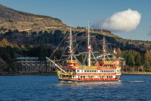 a large boat on the water with a mountain at ハーモニーヒルズVilla箱根強羅 in Hakone