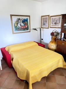 a bedroom with a bed with a yellow blanket on it at Villa Oasi Mariuccia - Relax e Mare in Lido di Jesolo