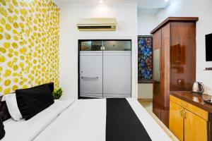 a bedroom with a large white bed and a cabinet at Hotel O Sector 5 Ghaziabad in Ghaziabad