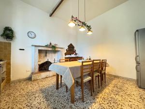 a dining room with a table and chairs and a fireplace at casa vacanze La Versilia in Vallecchia