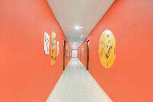 a hallway with orange walls and a surfboard on the wall at Townhouse Warangal Central Station in Warangal