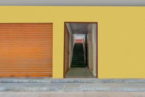 a yellow wall with a stairway leading up to a stair case at Townhouse Warangal Central Station in Warangal +23 photos