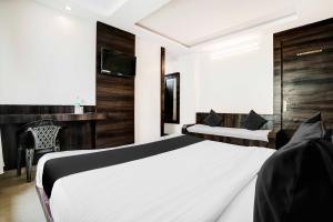 シルディにあるHotel O Shirdi Near Sai Baba Templeのベッド2台と机があるホテルの部屋