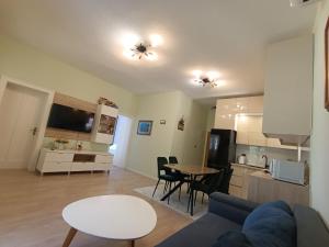a living room and kitchen with a couch and a table at Beachfront Apartment Deluxe in Podgora