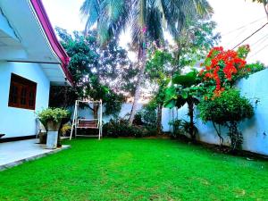 a yard of a house with a green lawn at Villa Serenity Weligama in Weligama