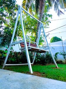 a swing in front of a palm tree at Villa Serenity Weligama in Weligama