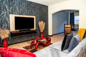 ein Wohnzimmer mit Sofa und Flachbildfernseher in der Unterkunft Freedom in Johannesburg
