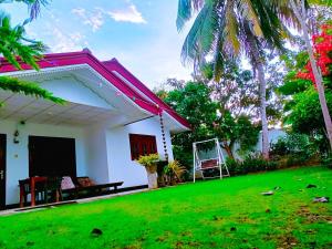 a house with a green lawn in front of it at Villa Serenity Weligama in Weligama