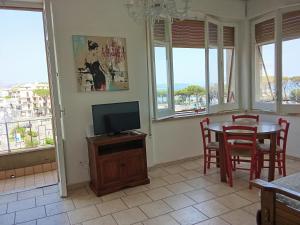 a living room with a tv and a table and chairs at holiday house MAURIZIO in Formia