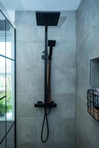 a shower with a black shower head in a bathroom at Avalon Sunrise our enchanting Glastonbury cottage in Glastonbury
