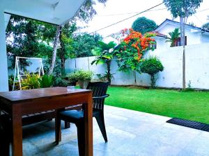 a wooden table and chairs in a yard at Villa Serenity Weligama in Weligama